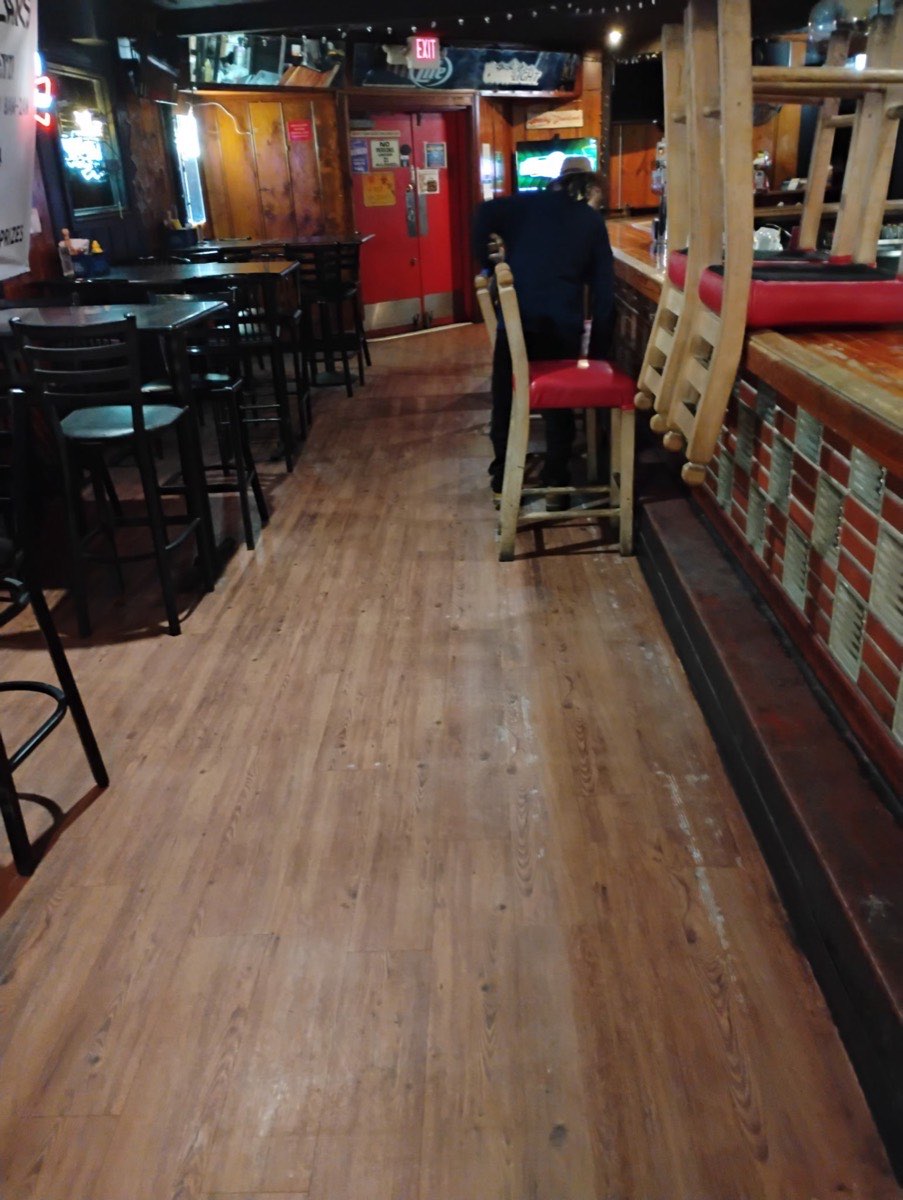 A clean wood-look floor along a bar