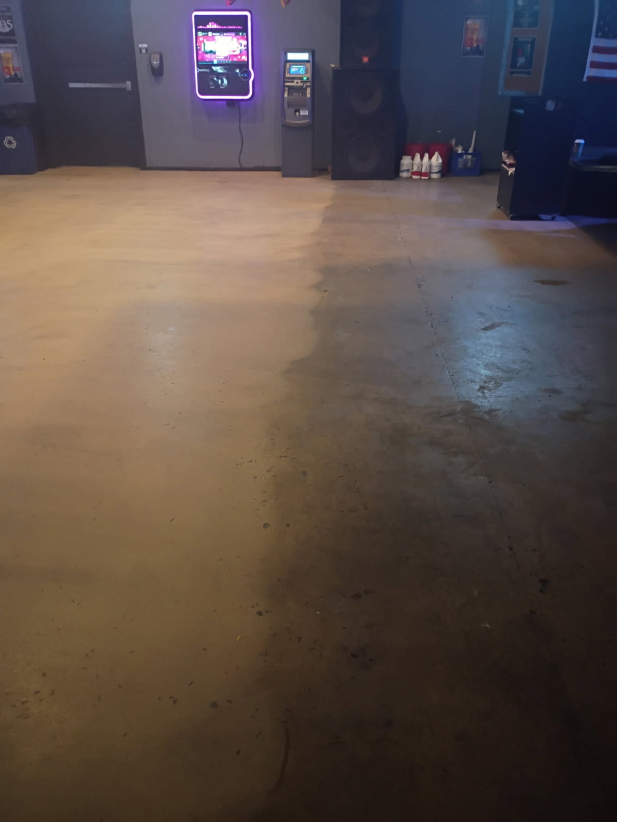 A bar floor with a lighter cleaned section on the left and a darker section on the right