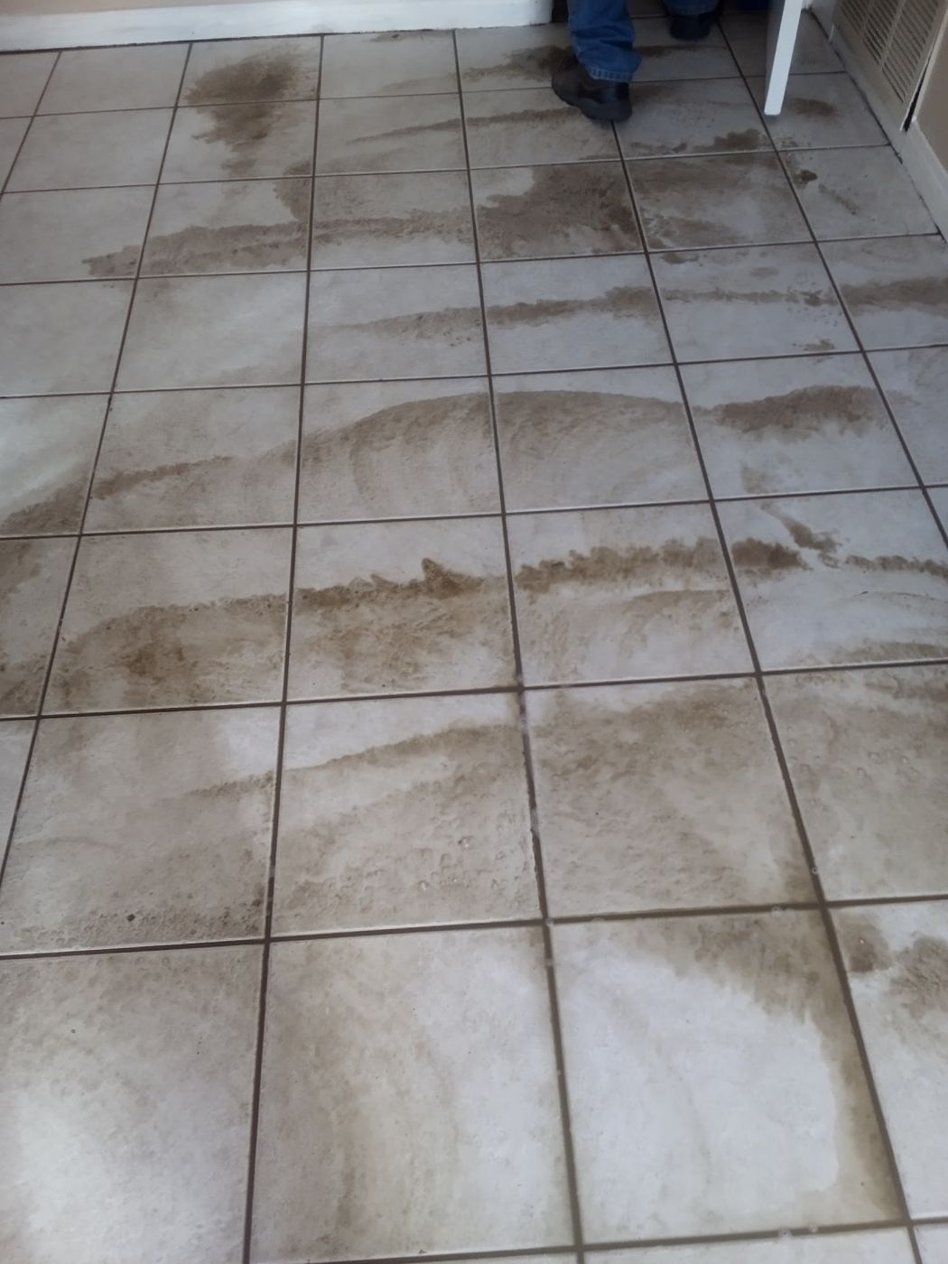 Tile floor being cleaned, with dirty and clean streaks