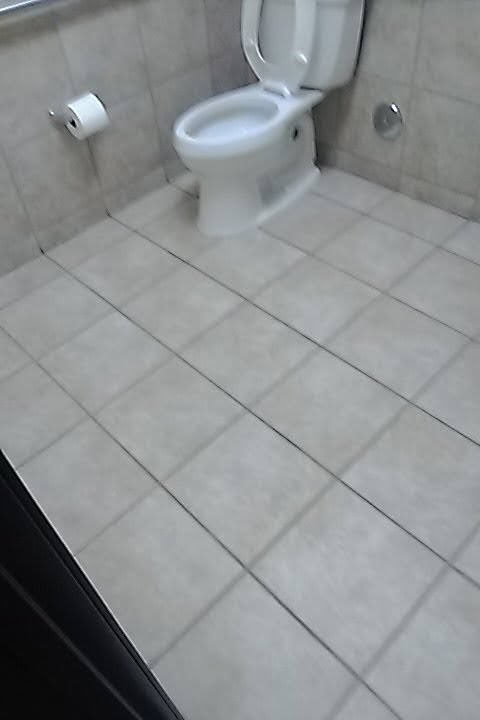 A clean bathroom tile floor beside a toilet