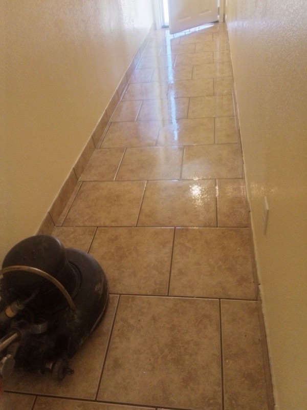 A hallway of tile with a scrubbing machine