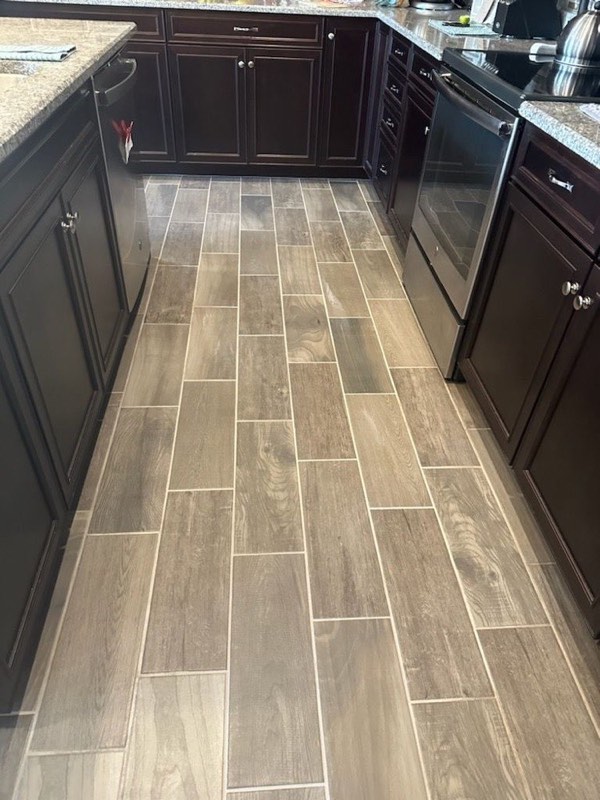 A kitchen with wood-look tile floor